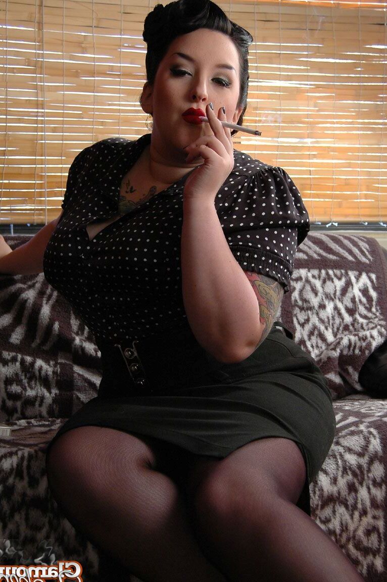 15P Fully clothed fat woman Kerosene wraps red lips around a cigarette