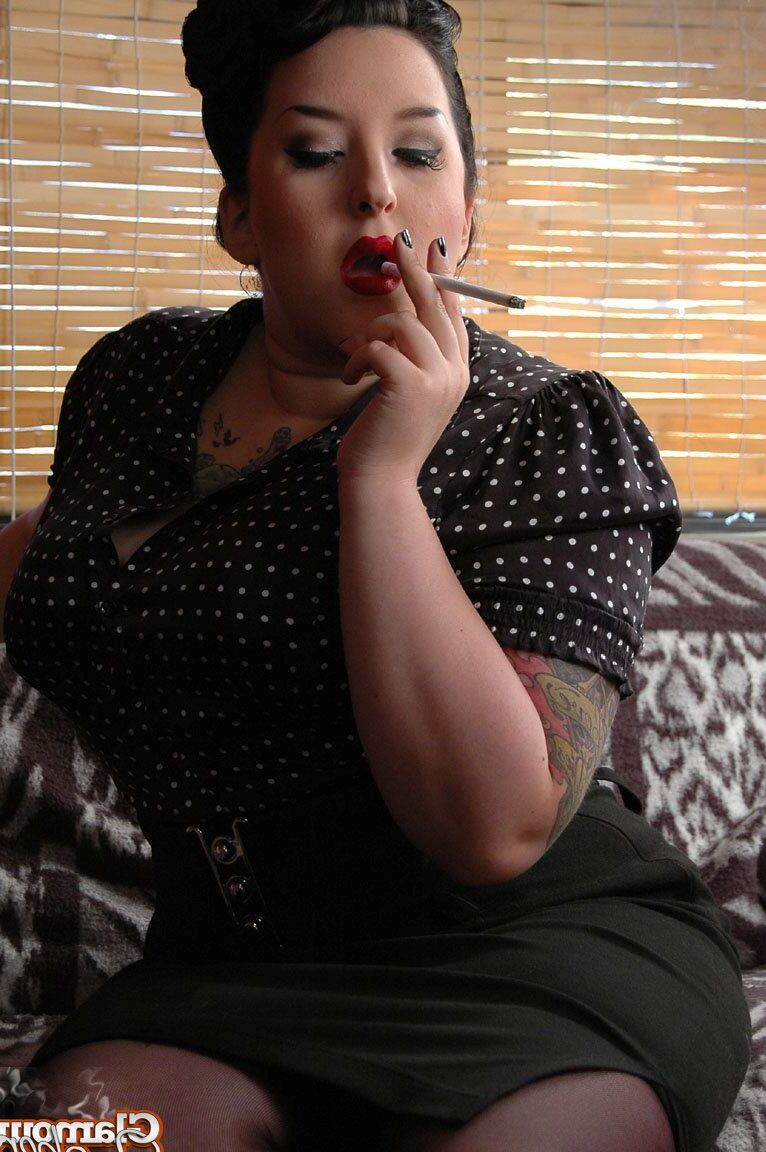 15P Fully clothed fat woman Kerosene wraps red lips around a cigarette