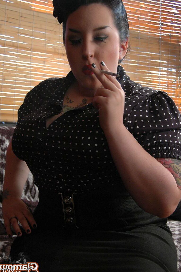 15P Fully clothed fat woman Kerosene wraps red lips around a cigarette