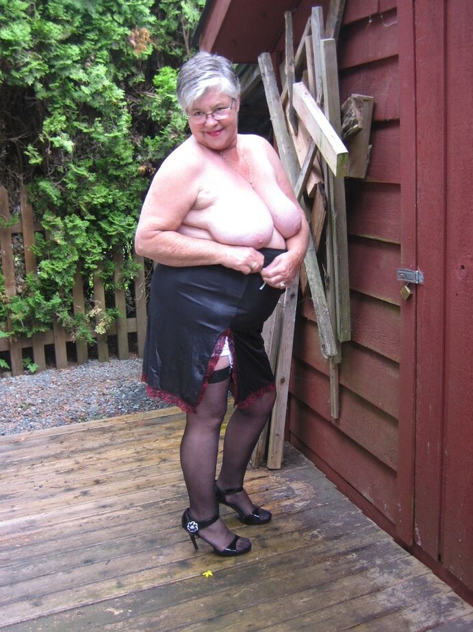 20P Fat oma Girdle Goddess обнажает свои большие сиськи рядом с заколоченным зданием