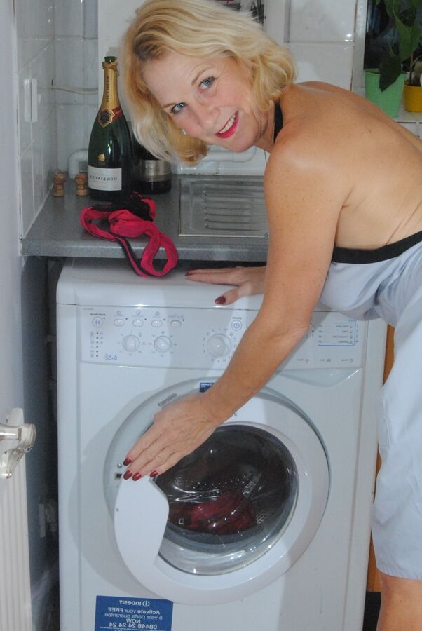 19P Mature MILF with blonde hair wears only an apron while devouring a banana