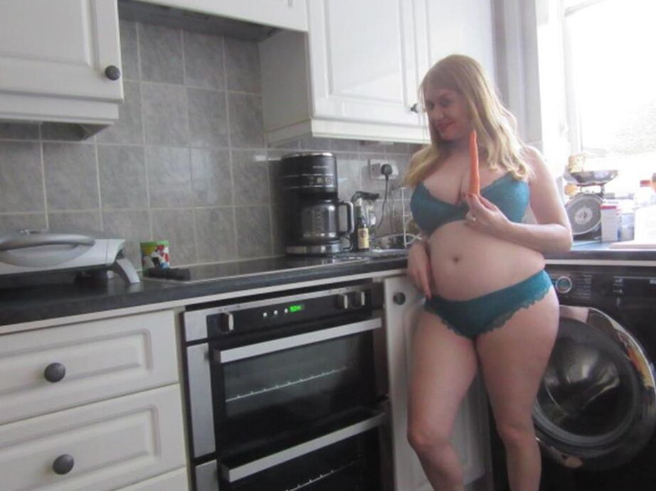 20P La curvilínea amateur británica Lily May se mete una zanahoria en el coño después de acariciarse las tetas