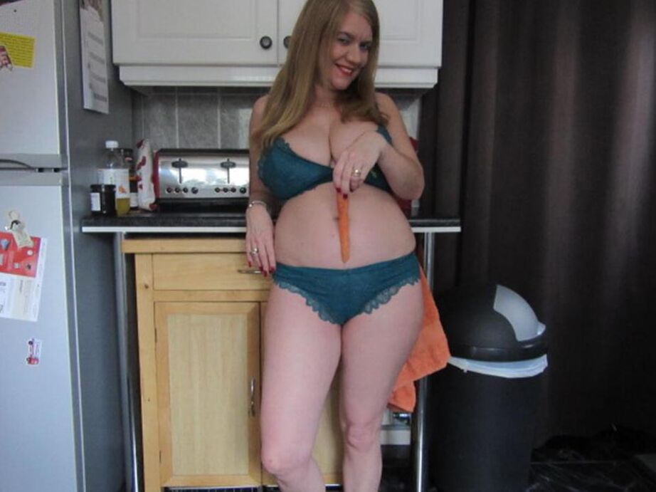 20P La curvilínea amateur británica Lily May se mete una zanahoria en el coño después de acariciarse las tetas