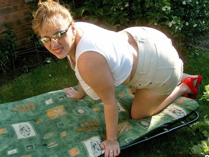 Curvy Claire, amateur britannique de 20P, montre ses seins sur une chaise de jardin tout en suçant un gode.
