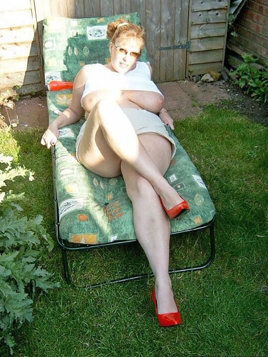 Curvy Claire, amateur britannique de 20P, montre ses seins sur une chaise de jardin tout en suçant un gode.