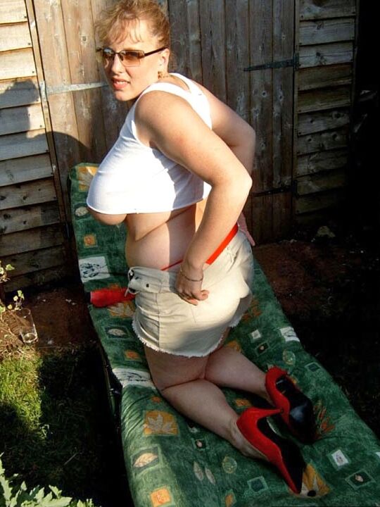 Curvy Claire, amateur britannique de 20P, montre ses seins sur une chaise de jardin tout en suçant un gode.