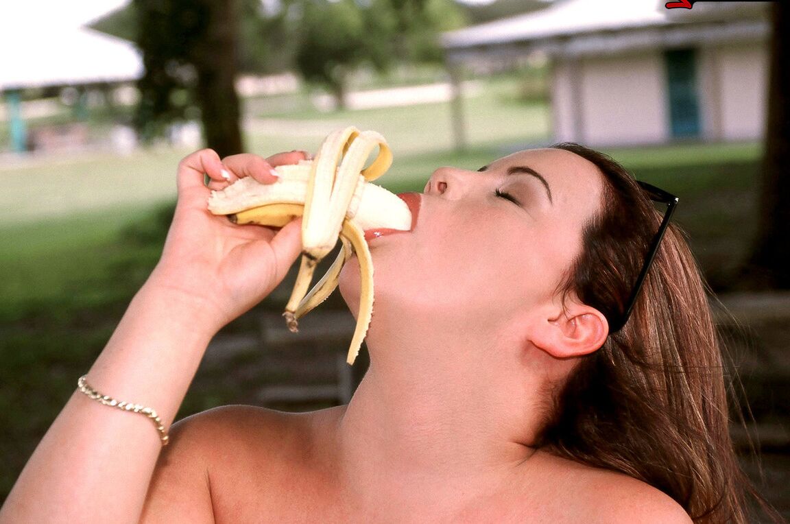 15P Thick chick Annie Swanson eats a banana before baring her breasts in a park