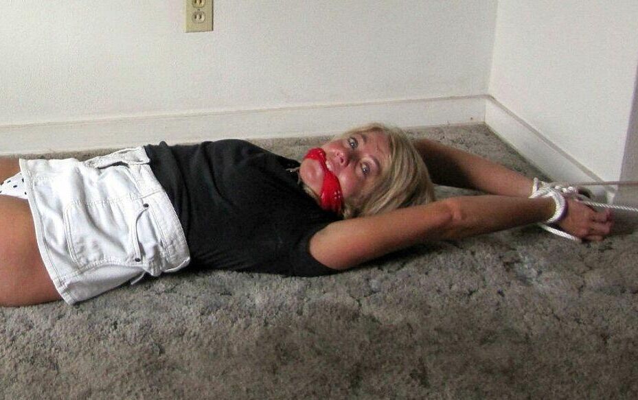 14P Blonde woman is gagged while her ankles and wrists are bound with rope