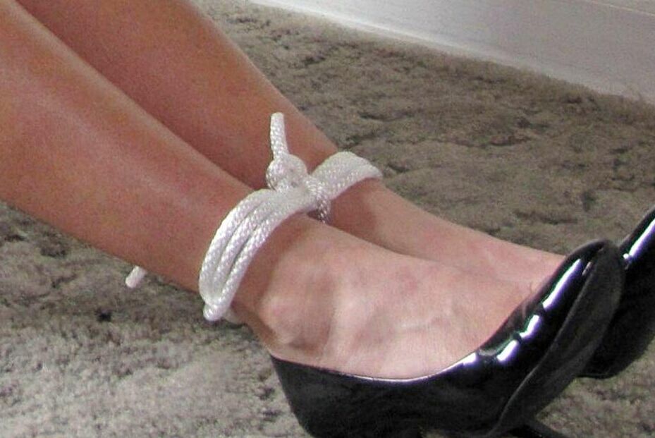 14P Blonde woman is gagged while her ankles and wrists are bound with rope