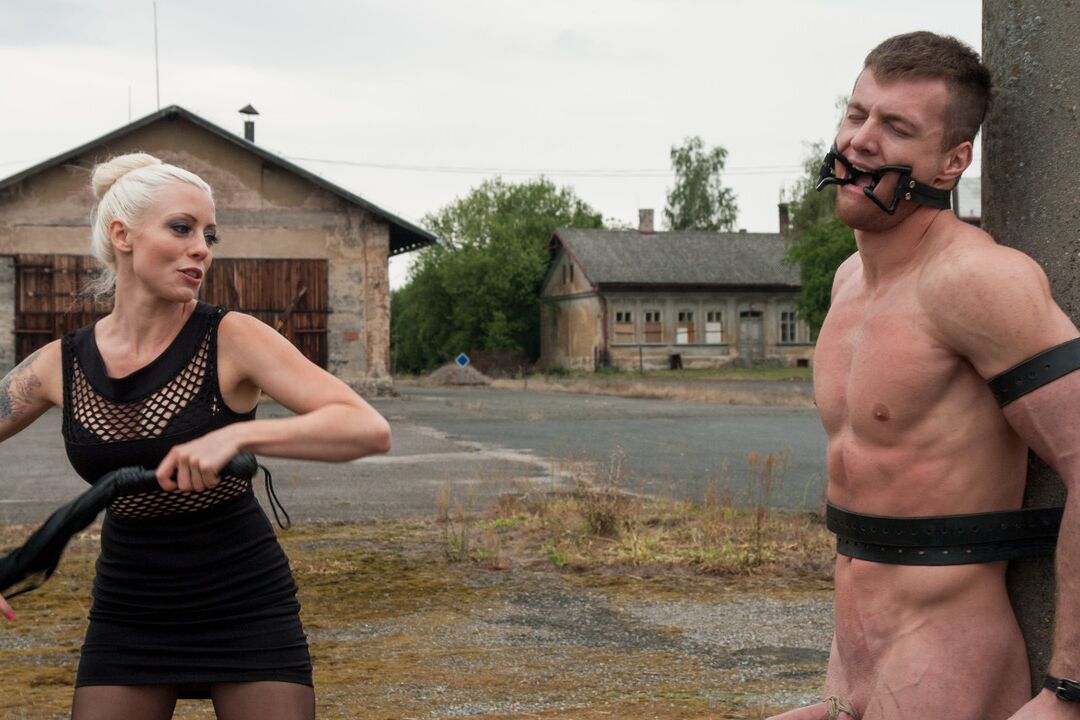 21P La domme blonde en robe noire Lorelei Lee torture son esclave attachée à un poteau