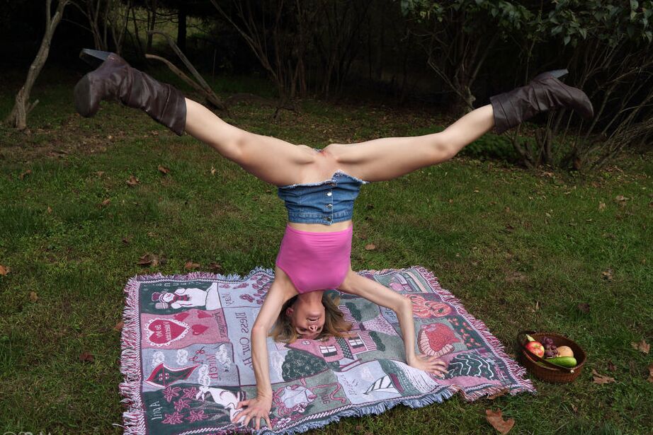 Die 16-jährige Amateurin Addee Kate macht einen Handstand, bevor sie im Garten mit ihrer Muschi spielt