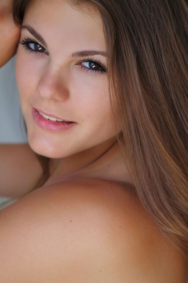 Lora N, mannequin adolescente 16P, tient ses seins flasques tout en exhibant sa jolie chatte.