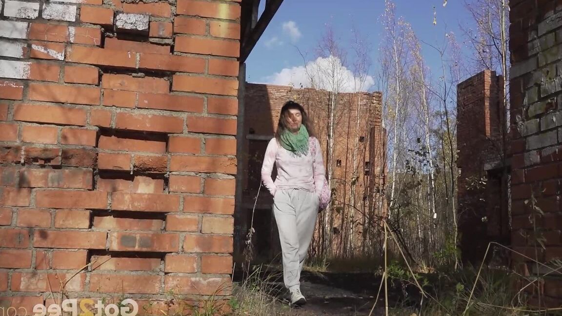 15P Caucasian girl Rita takes a badly needed piss behind a derelict brick building