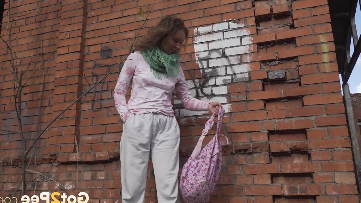 15P Caucasian girl Rita takes a badly needed piss behind a derelict brick building