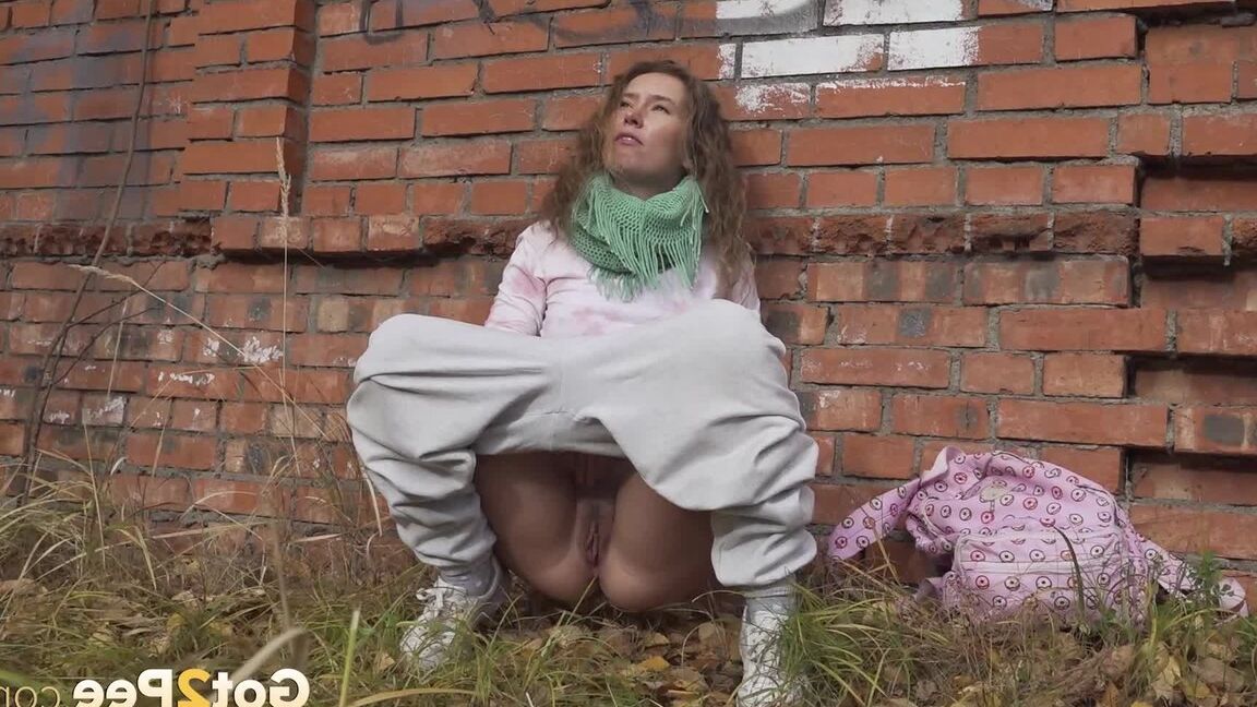 15P Caucasian girl Rita takes a badly needed piss behind a derelict brick building