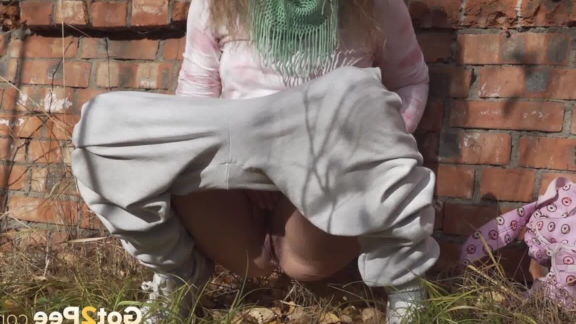 15P Caucasian girl Rita takes a badly needed piss behind a derelict brick building