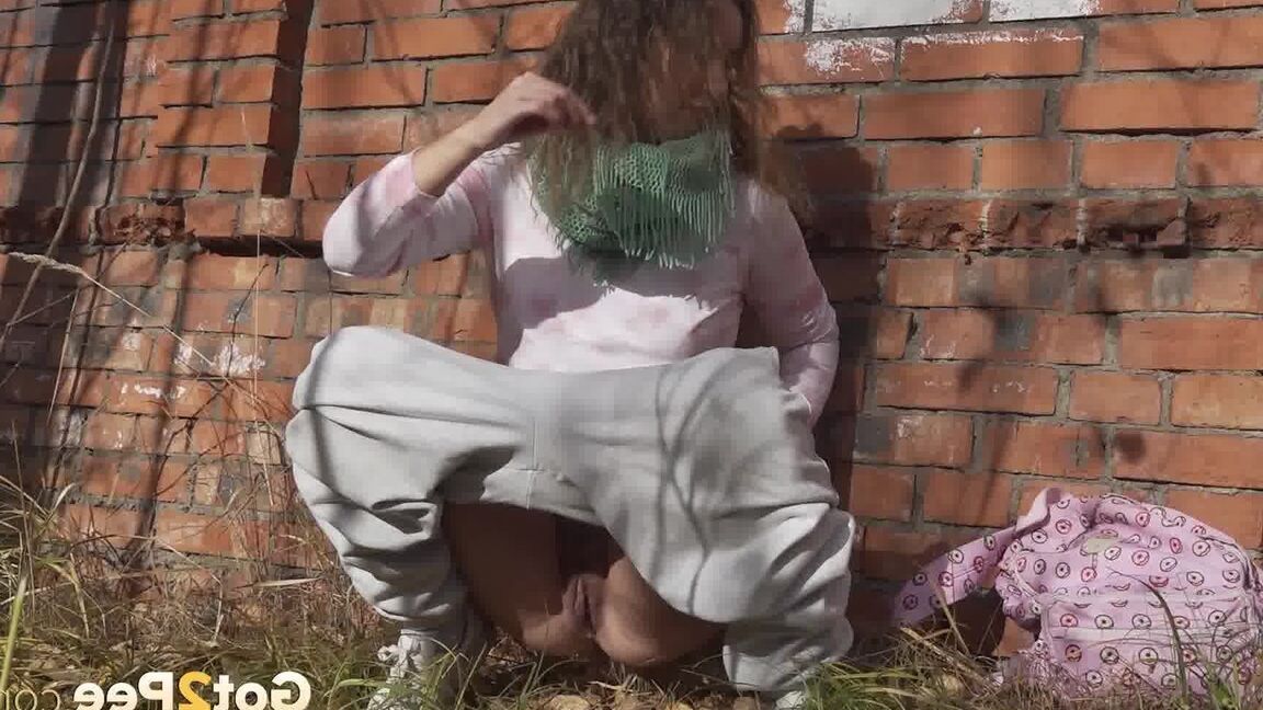 15P Caucasian girl Rita takes a badly needed piss behind a derelict brick building