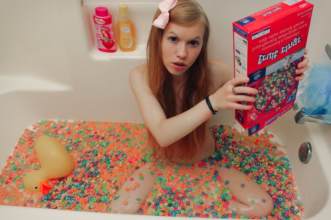 15P Young looking girl Dolly Little empties a box of cereal into her bathwater