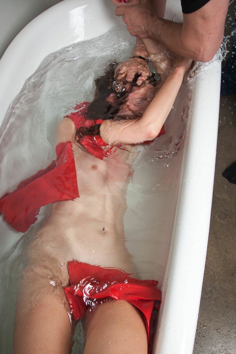 16P Leggy brunette works free of red latex clothing while being drowned in a tub