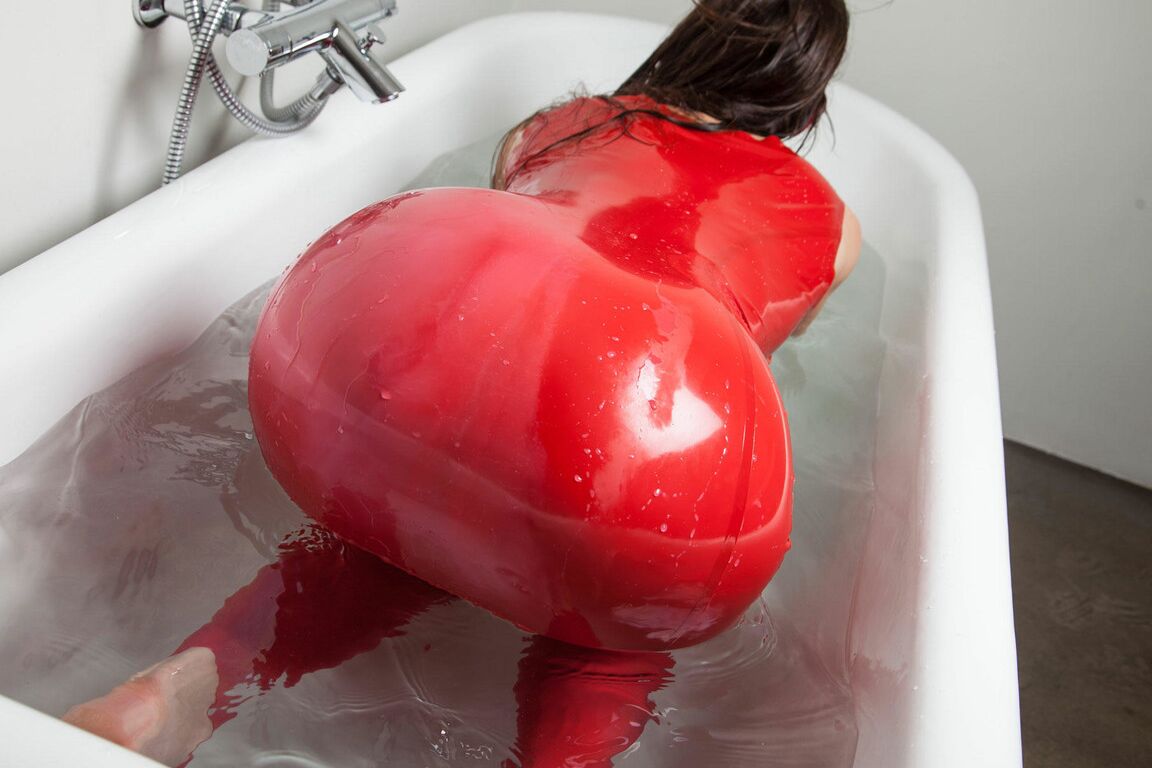 16P Leggy brunette works free of red latex clothing while being drowned in a tub