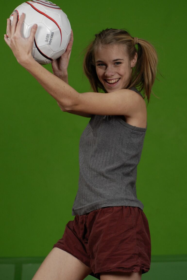 16P La pequeña Kelly expone un pecho mientras sostiene un balón de fútbol
