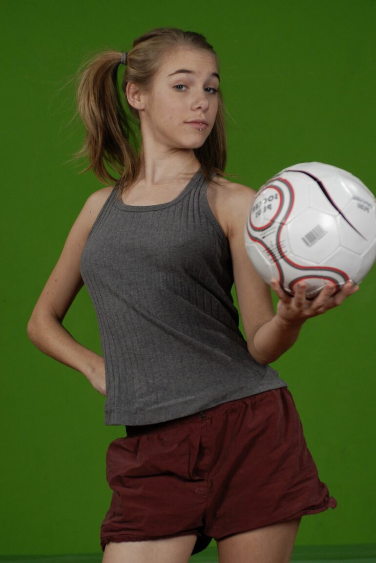 16P La pequeña Kelly expone un pecho mientras sostiene un balón de fútbol