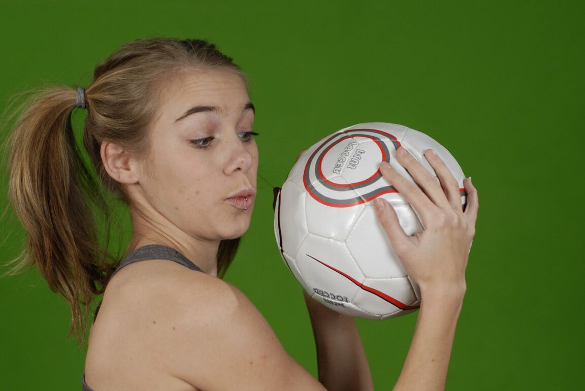 16P La pequeña Kelly expone un pecho mientras sostiene un balón de fútbol