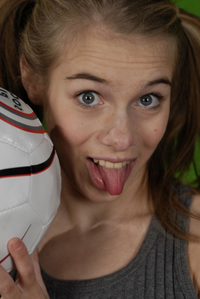 16P La pequeña Kelly expone un pecho mientras sostiene un balón de fútbol