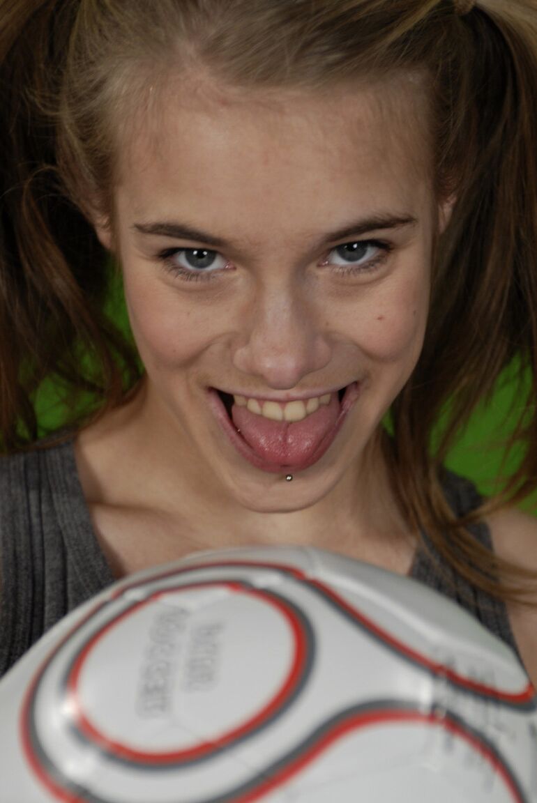 16P La pequeña Kelly expone un pecho mientras sostiene un balón de fútbol