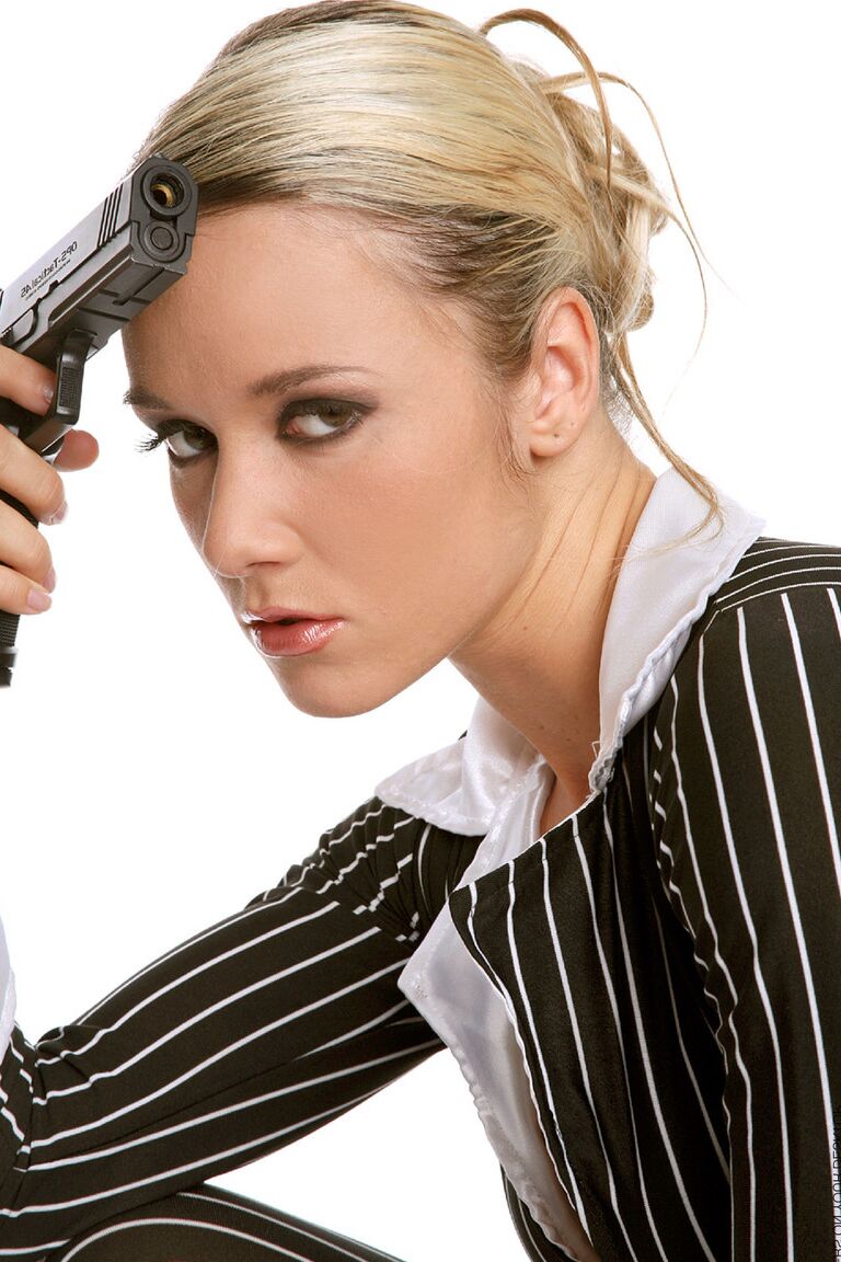 15P A loira sexy Jana H empunha uma pistola enquanto tira a roupa e fica com saltos brancos