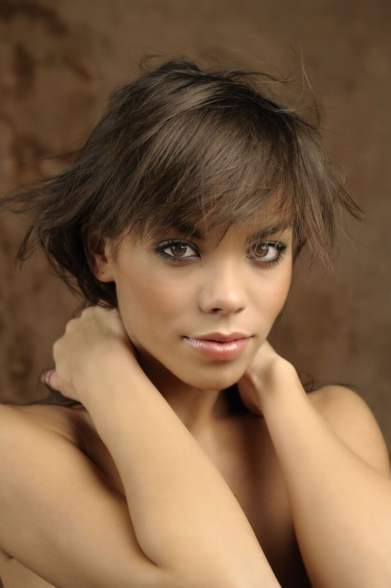16P Une belle fille avec un joli visage enfile un chapeau d'hiver lors d'une séance glamour
