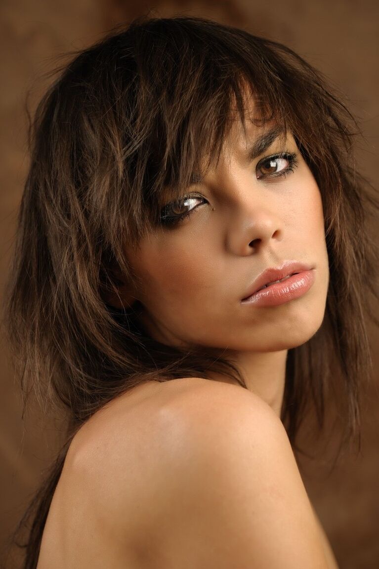 16P Une belle fille avec un joli visage enfile un chapeau d'hiver lors d'une séance glamour
