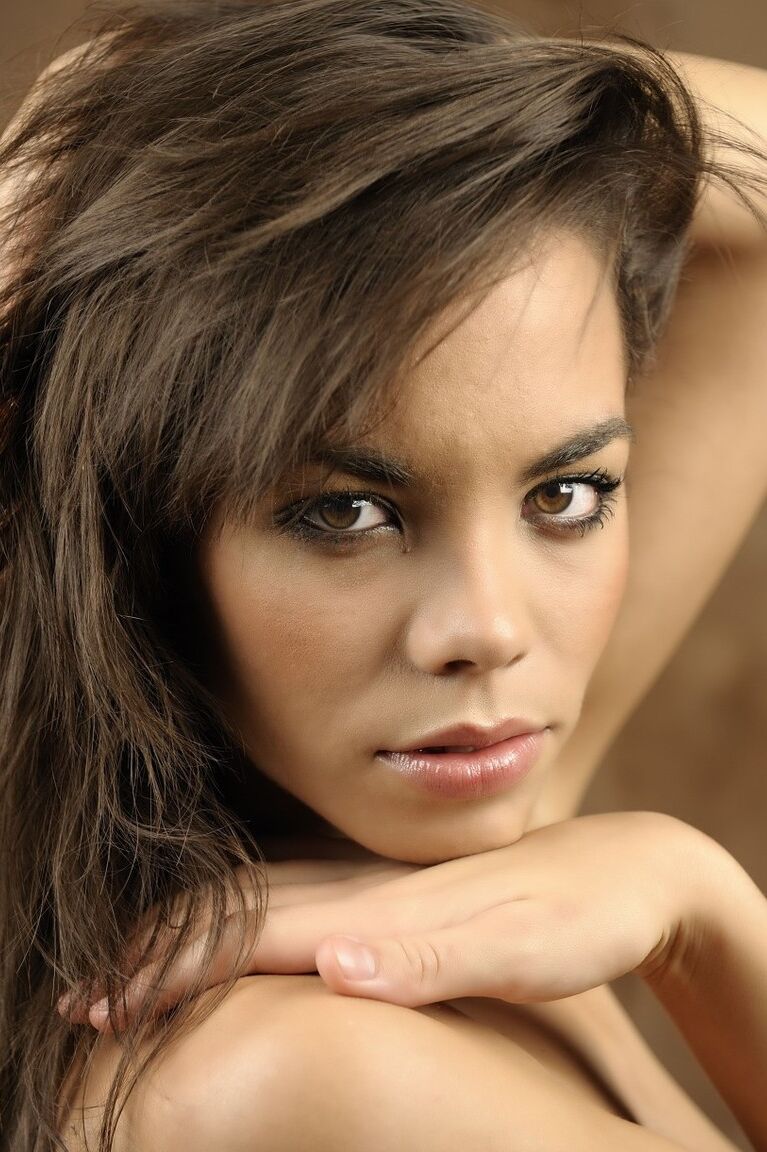 16P Une belle fille avec un joli visage enfile un chapeau d'hiver lors d'une séance glamour