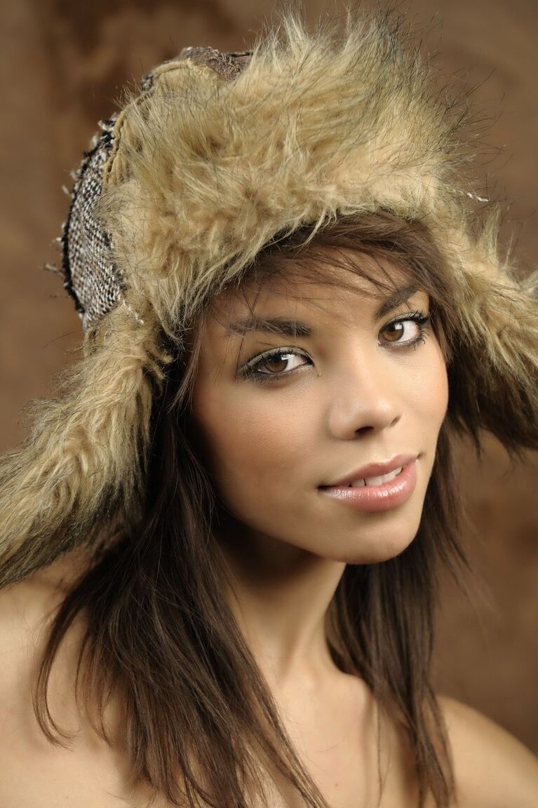 16P Une belle fille avec un joli visage enfile un chapeau d'hiver lors d'une séance glamour