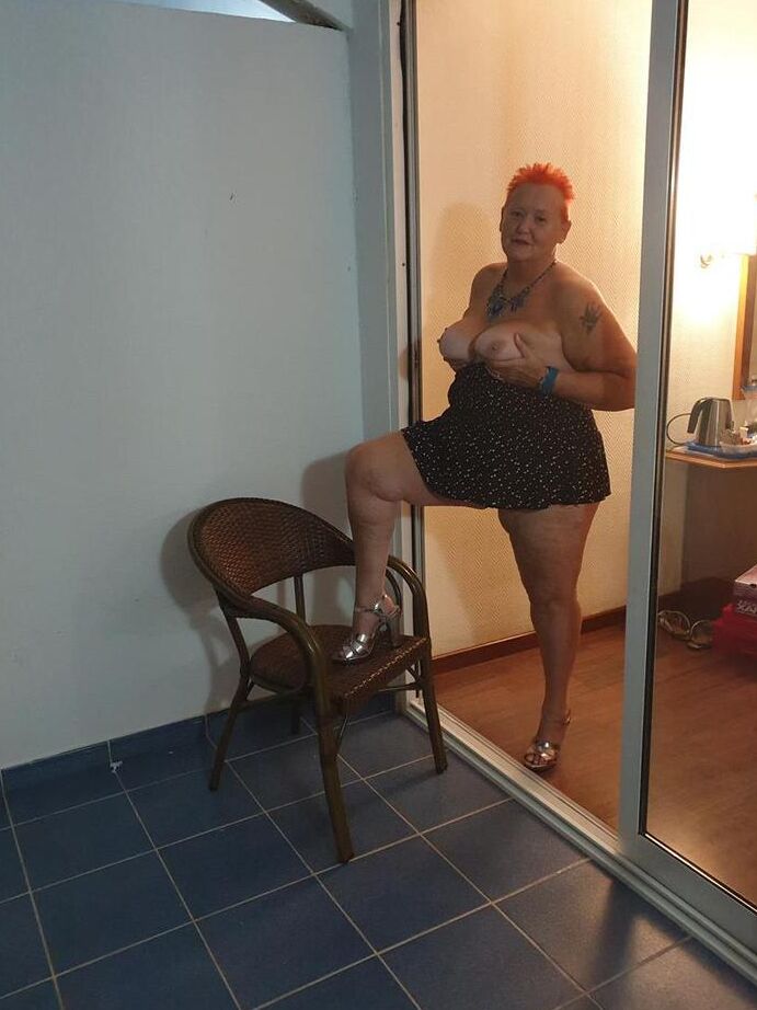 20P Nan gorda con el pelo rojo corto presiona sus grandes tetas y su trasero contra el vidrio