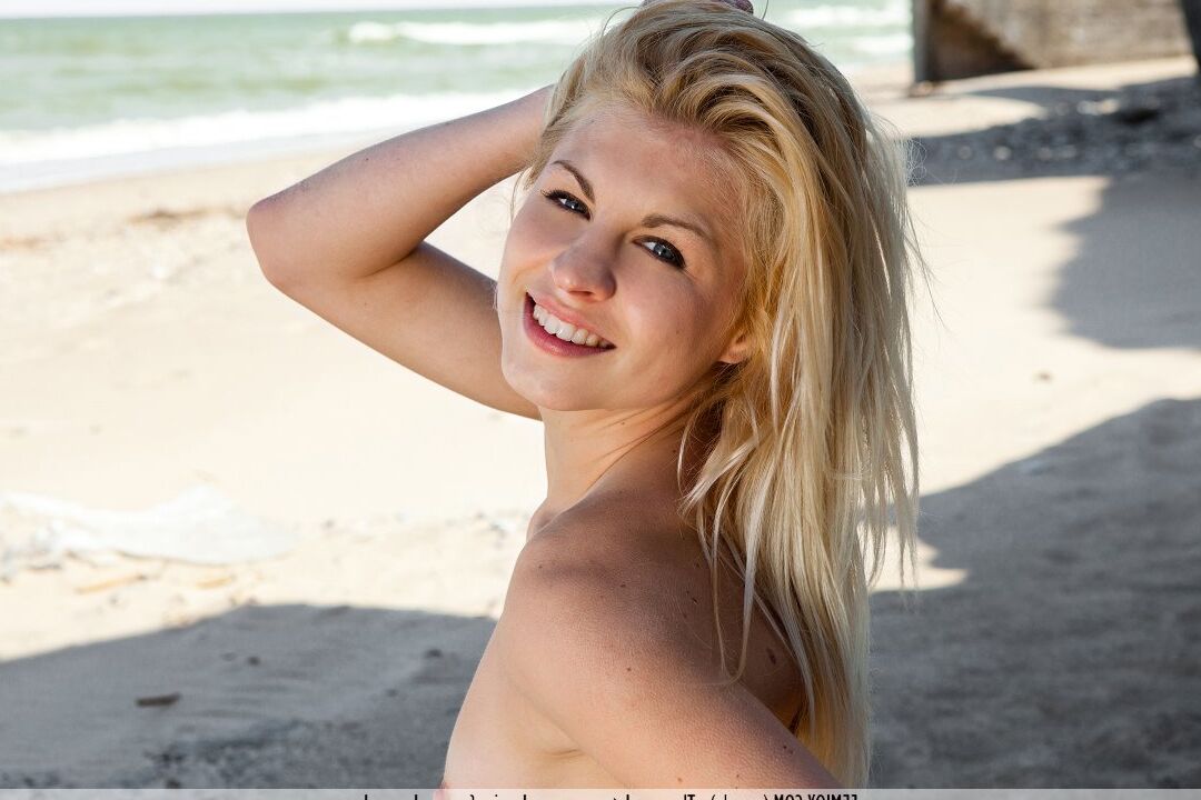16P Die völlig nackte Blondine Lea T macht tolle Solo-Posen im Schatten eines Strandes