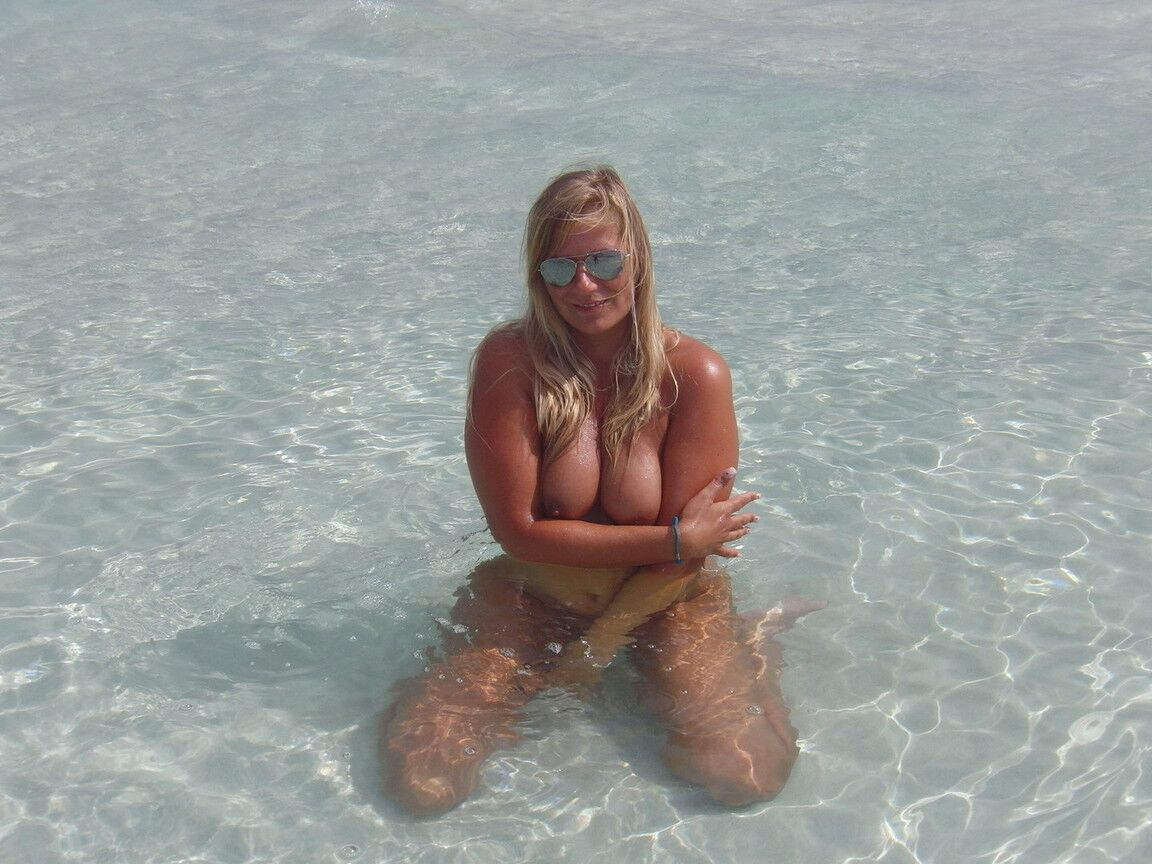 16P Middle-aged blonde Sweet Susi wades into the ocean while totally naked