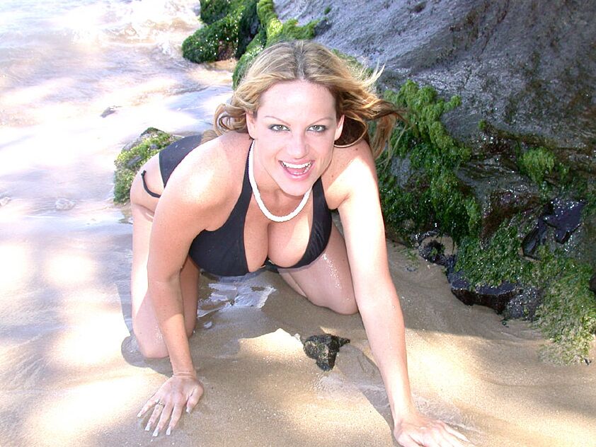 MILF américaine 16P en lingerie noire Kelly Madison posant sur la plage