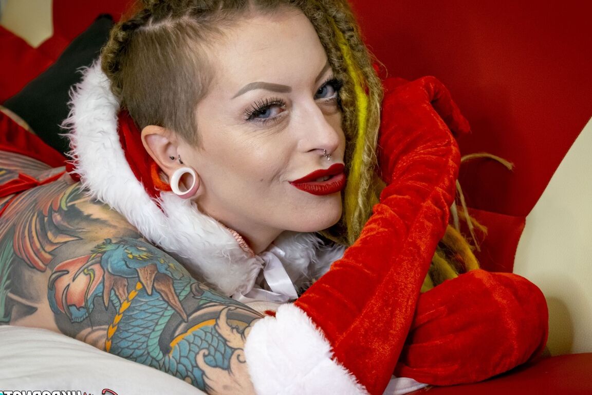 16P La chica tatuada Piggymouth luce rastas de colores brillantes durante una sesión fotográfica navideña