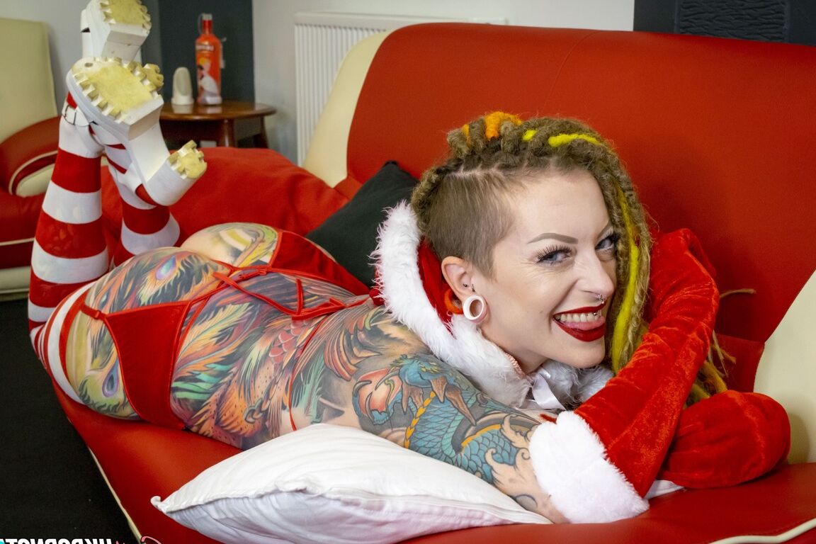 16P La chica tatuada Piggymouth luce rastas de colores brillantes durante una sesión fotográfica navideña