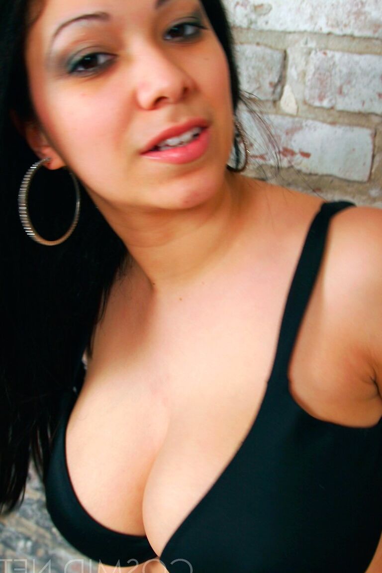 16P Elizabeth, une fille aux cheveux noirs, place ses mains sur ses gros seins