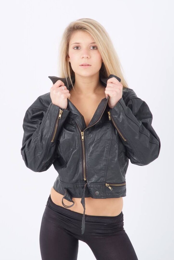 15P Blond chick unzips her leather jacket in a black bra and leggings