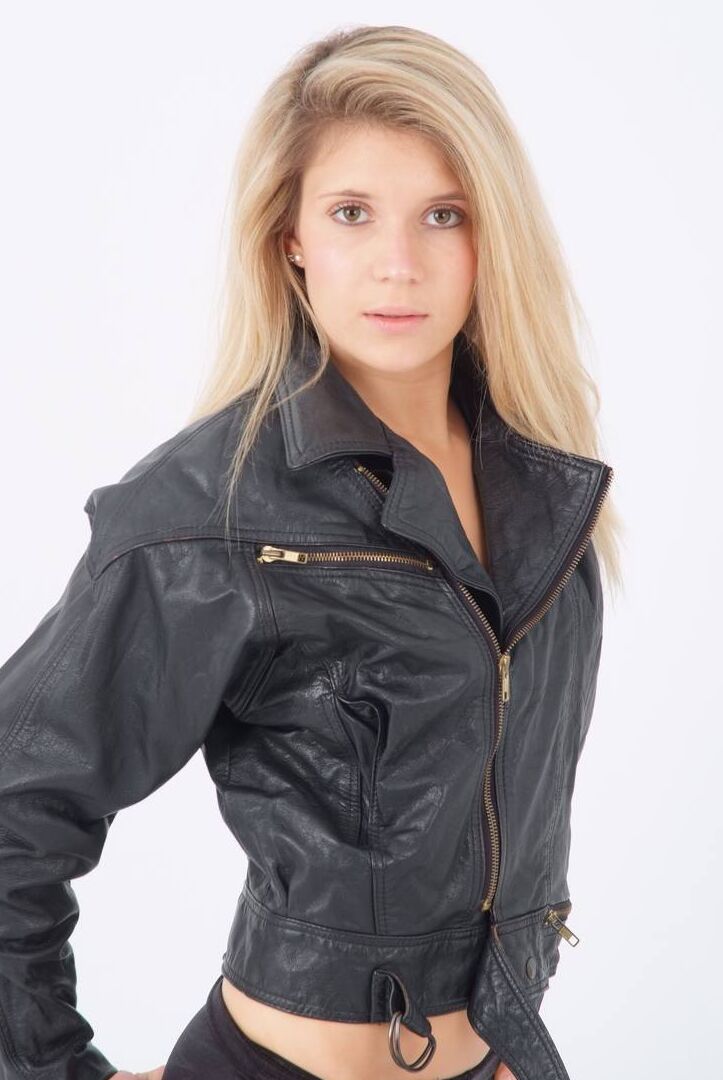 15P Blond chick unzips her leather jacket in a black bra and leggings