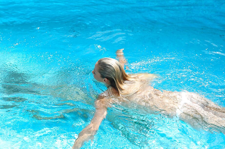 16P La jeune blonde Christen nage nue dans la piscine et se masturbe