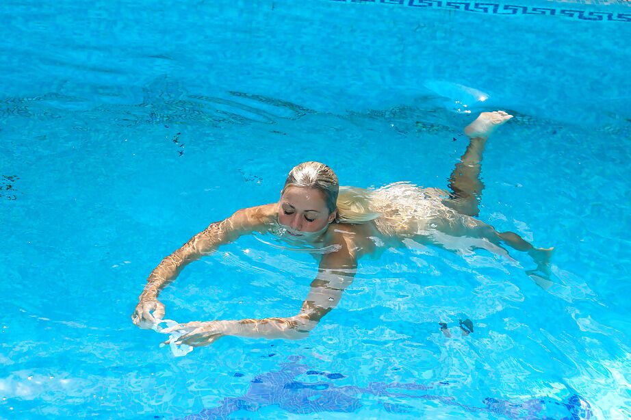16P La jeune blonde Christen nage nue dans la piscine et se masturbe