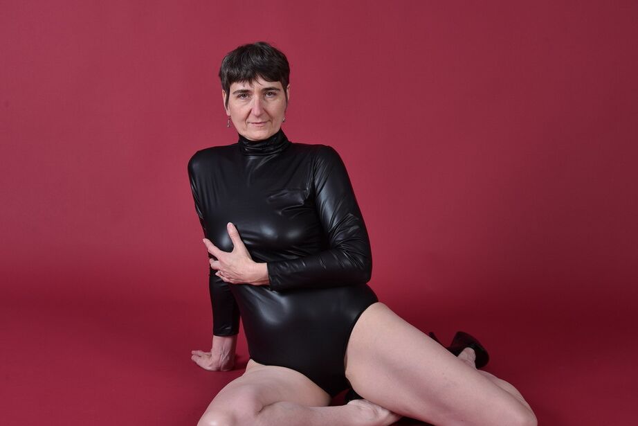 20P Short haired older brunette shows her bald pussy while modelling totally naked