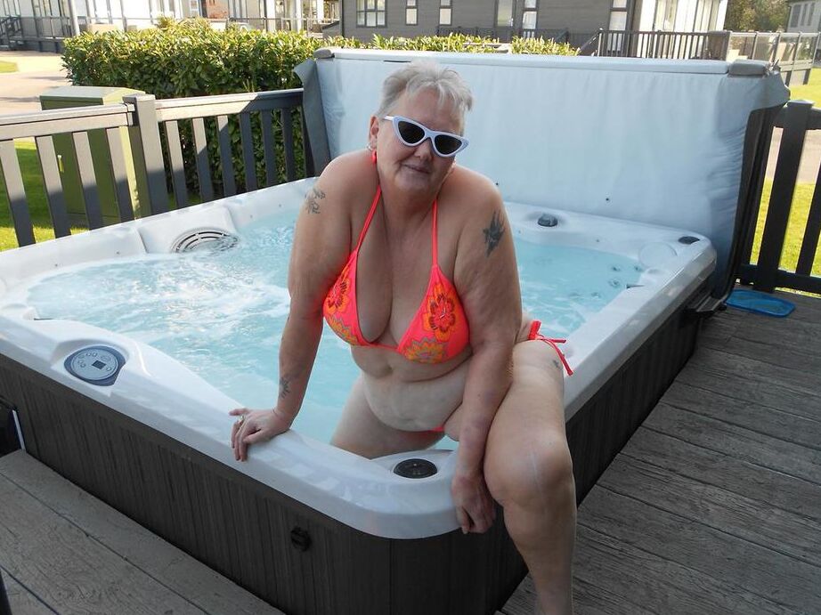 20P Fat nan bares her boobs while in a patio hot tub before getting naked on a bed