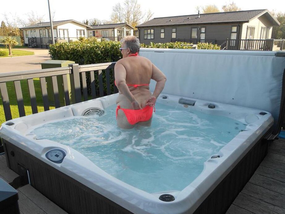 20P Fat nan bares her boobs while in a patio hot tub before getting naked on a bed