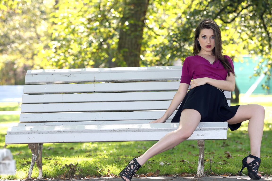 21P La superbe européenne Serena pose sur un banc de parc dans une jupe courte sexy.