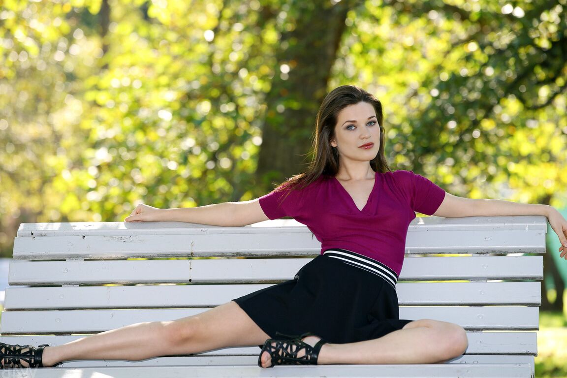 21P La superbe européenne Serena pose sur un banc de parc dans une jupe courte sexy.